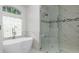 Modern bathroom featuring a soaking tub, glass-enclosed shower, and marble accents at 18652 Ohara Dr, Port Charlotte, FL 33948