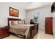 Cozy bedroom with a window view, side table with lamp, and traditional-style furnishings at 18652 Ohara Dr, Port Charlotte, FL 33948