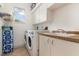 Well-equipped laundry room with tile floor, washer, dryer, sink, and ample storage space at 18652 Ohara Dr, Port Charlotte, FL 33948
