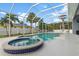Relaxing pool and spa area surrounded by lush tropical landscaping and an enclosed lanai at 18652 Ohara Dr, Port Charlotte, FL 33948