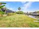 Spacious backyard, green grass, and dock over the water at 18753 Klingler Cir, Port Charlotte, FL 33948