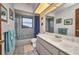 Bathroom featuring blue tiled shower with glass door, toilet, and marble vanity at 18753 Klingler Cir, Port Charlotte, FL 33948