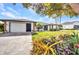 Well-maintained home featuring a large driveway, attached garage, and beautiful landscaping at 18753 Klingler Cir, Port Charlotte, FL 33948