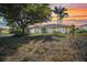 Charming single-story home with a well-manicured lawn and mature trees at sunset at 18753 Klingler Cir, Port Charlotte, FL 33948