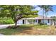 Well-maintained home featuring a manicured lawn, a beautiful tree, and an attached two-car garage at 18753 Klingler Cir, Port Charlotte, FL 33948