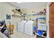 Functional laundry room is equipped with washer, dryer, sink, and storage shelves at 18753 Klingler Cir, Port Charlotte, FL 33948