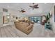 Open living room featuring ceiling fans and sliding glass doors providing natural light and access to the pool area at 18753 Klingler Cir, Port Charlotte, FL 33948