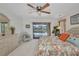 Bright main bedroom featuring neutral carpet, ceiling fan, and sliding doors to the pool at 18753 Klingler Cir, Port Charlotte, FL 33948