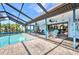 Inviting screened-in pool area with brick pavers and comfortable lounge seating, perfect for relaxation at 18753 Klingler Cir, Port Charlotte, FL 33948