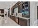 Custom bar area features marble countertops, glass-front cabinets, wine coolers, and stylish storage for drinks at 19 Sabal Dr, Punta Gorda, FL 33950