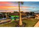 Sunset view of dock with boat lift and jet ski lift, with vibrant sky at 19 Sabal Dr, Punta Gorda, FL 33950
