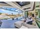 This luxurious outdoor patio features a comfortable lounge area, canal views, and a covered pool area at 19 Sabal Dr, Punta Gorda, FL 33950