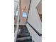 Modern staircase with black wood steps and glass railings near wine cellar at 19 Sabal Dr, Punta Gorda, FL 33950
