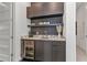 Modern wet bar with mini-fridge, sleek black cabinets, marble counter top, and coffee accessories at 19 Sabal Dr, Punta Gorda, FL 33950