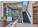 An elegant, climate-controlled glass wine cellar is located near a modern staircase at 19 Sabal Dr, Punta Gorda, FL 33950