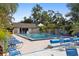 Spacious community pool area with abundant lounge seating and mature landscaping is perfect for relaxation and recreation at 19505 Quesada Ave # A204, Port Charlotte, FL 33948