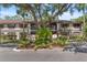 Charming condo building featuring mature trees, lush landscaping, and ample parking at 19505 Quesada Ave # A204, Port Charlotte, FL 33948