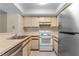 A well-lit kitchen featuring white appliances, light countertops, and ample cabinet space at 19505 Quesada Ave # A204, Port Charlotte, FL 33948