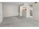 Open living room area with neutral carpet and a kitchen view at 19505 Quesada Ave # A204, Port Charlotte, FL 33948