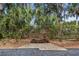 A charming wooden bench offers a peaceful spot amidst lush greenery, creating a serene outdoor seating area at 19505 Quesada Ave # A204, Port Charlotte, FL 33948