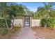 Landscaped walkway to the community pool area behind gate with lush greenery at 19505 Quesada Ave # A204, Port Charlotte, FL 33948