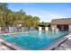 Inviting community pool featuring clear blue water, lounge chairs, and lush tropical landscaping at 19505 Quesada Ave # A204, Port Charlotte, FL 33948