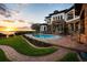 Lush backyard oasis with pool, spa, and stunning sunset views, enhanced by manicured landscaping and stone architecture at 2107 4Th Street W Ct, Palmetto, FL 34221