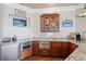 Bar area with granite counters, stainless steel appliances including a microwave, glass cabinet and waterfront themed decor at 2107 4Th Street W Ct, Palmetto, FL 34221
