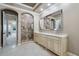 Beautiful bathroom featuring a stone shower, arched doorway, and a large vanity with double sinks at 2107 4Th Street W Ct, Palmetto, FL 34221