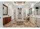 This bathroom has a central vanity, an elegant chandelier, stone floors, and separate vanity areas at 2107 4Th Street W Ct, Palmetto, FL 34221