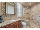 Modern bathroom featuring a glass shower, wooden vanity, granite counters, and decorative mirror at 2107 4Th Street W Ct, Palmetto, FL 34221