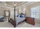 Relax in this primary bedroom featuring a four-poster bed, tray ceilings, and plantation shutters at 2107 4Th Street W Ct, Palmetto, FL 34221