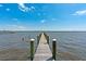 Picturesque view of a wooden dock stretching into the tranquil water under a clear blue sky at 2107 4Th Street W Ct, Palmetto, FL 34221