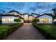 Stunning estate featuring a long brick driveway and meticulously manicured landscaping at dusk at 2107 4Th Street W Ct, Palmetto, FL 34221
