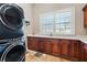 Well-equipped laundry room with stacked washer/dryer, ample counter space, and custom wood cabinets at 2107 4Th Street W Ct, Palmetto, FL 34221
