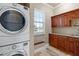 Functional laundry room equipped with modern washer and dryer, wooden cabinets, and countertop space at 2107 4Th Street W Ct, Palmetto, FL 34221