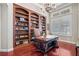 Sophisticated office features dark wood built-ins, wood floors, and plantation shutters for refined workspace at 2107 4Th Street W Ct, Palmetto, FL 34221