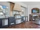 Covered outdoor kitchen with stainless grill, and adjacent seating by a stone fireplace with wall mounted TV at 2107 4Th Street W Ct, Palmetto, FL 34221