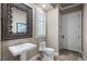 Elegant powder room featuring detailed mirror, pedestal sink, and plantation shutters at 2107 4Th Street W Ct, Palmetto, FL 34221