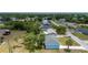 An aerial perspective reveals the home positioned in a vibrant residential neighborhood with lush trees and greenery at 21480 Eldred Ave, Port Charlotte, FL 33952