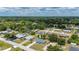 Bird's eye view shows a light-blue single-story home surrounded by lush greenery in a quiet residential neighborhood at 21480 Eldred Ave, Port Charlotte, FL 33952