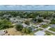 An aerial view depicts the home in a well-established residential neighborhood with mature trees and vibrant greenery at 21480 Eldred Ave, Port Charlotte, FL 33952