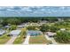 An aerial view shows the light-blue single-story home in a serene residential neighborhood surrounded by lush trees at 21480 Eldred Ave, Port Charlotte, FL 33952