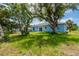 The backyard features mature trees, a patio, and lush lawn for outdoor enjoyment at 21480 Eldred Ave, Port Charlotte, FL 33952