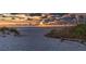 Scenic beach with sand dunes, native plants, and a rustic bench under a dramatic sunset sky at 21480 Eldred Ave, Port Charlotte, FL 33952