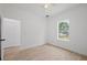 Bright bedroom featuring neutral paint, wood-look tile flooring, white trim, and a view to the backyard at 21480 Eldred Ave, Port Charlotte, FL 33952