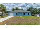 Charming light-blue single-story home with a one-car garage and well-manicured front yard at 21480 Eldred Ave, Port Charlotte, FL 33952
