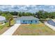 Charming light-blue single-story home with a one-car garage, manicured front yard, and a palm tree at 21480 Eldred Ave, Port Charlotte, FL 33952
