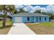 Charming single-story home with a white garage door and driveway at 21480 Eldred Ave, Port Charlotte, FL 33952