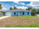 Single-story blue home with a well-maintained lawn and attached garage at 21480 Eldred Ave, Port Charlotte, FL 33952